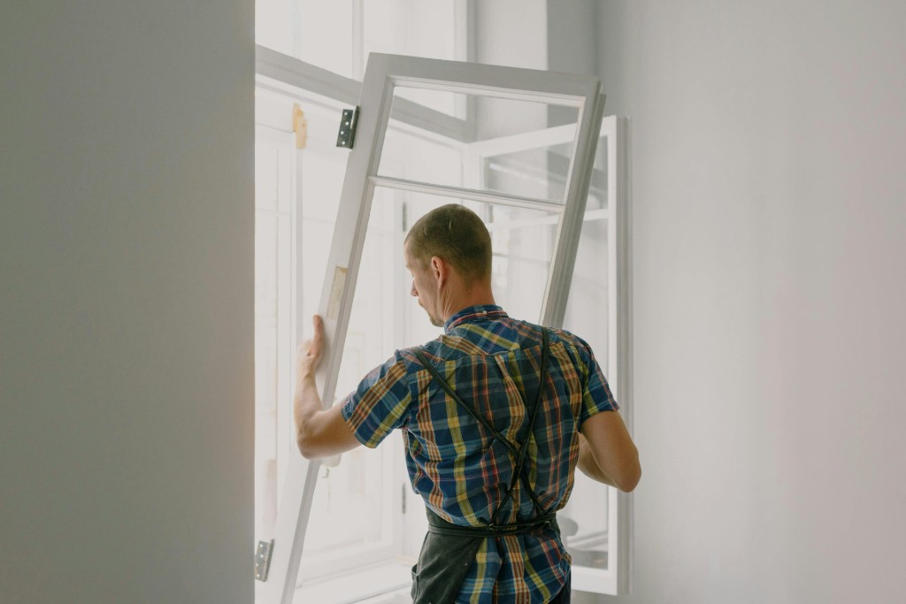 Home service technician fitting a window frame
