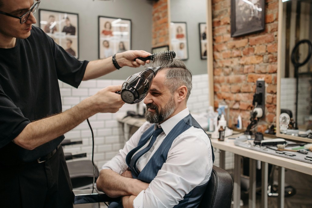 Barber styling client in a modern barbershop