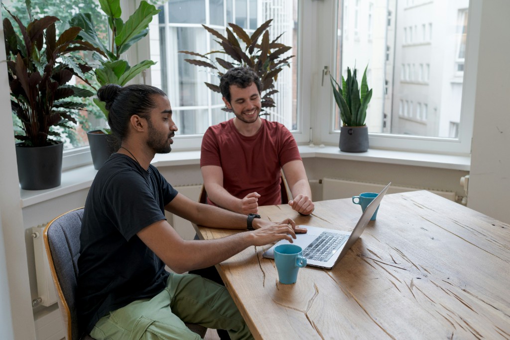 Two consultants collaborating over a laptop during training